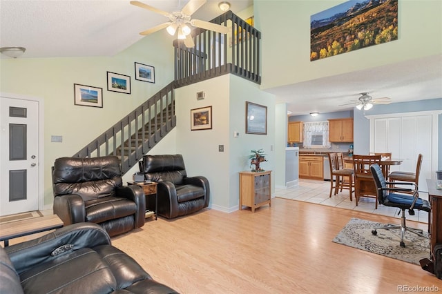 4929 Witches Hollow Ln, Colorado Springs, CO 80911 - living area featuring ceiling fan, light wood-style flooring, stairway, and high vaulted ceiling