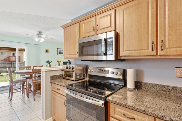4929 Witches Hollow Ln, Colorado Springs, CO 80911 - kitchen featuring stainless steel appliances, light brown cabinets, ceiling fan, light tile patterned floors, and a textured ceiling