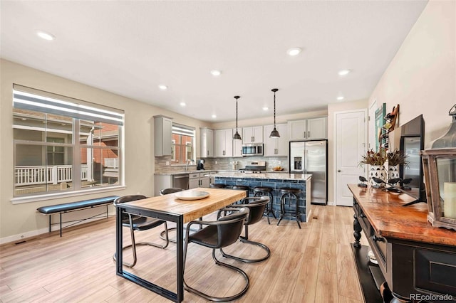 dining area with baseboards, recessed lighting, and light wood-style floors