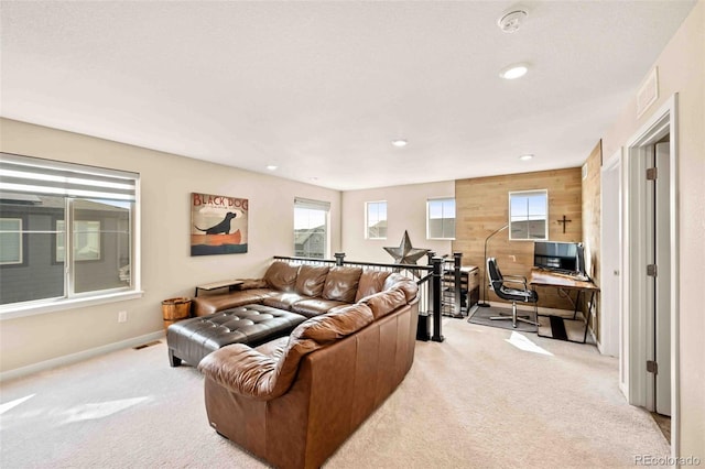 living room with recessed lighting, light carpet, wooden walls, and baseboards