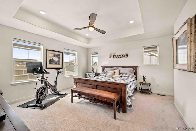 carpeted bedroom with visible vents, baseboards, a raised ceiling, a ceiling fan, and recessed lighting