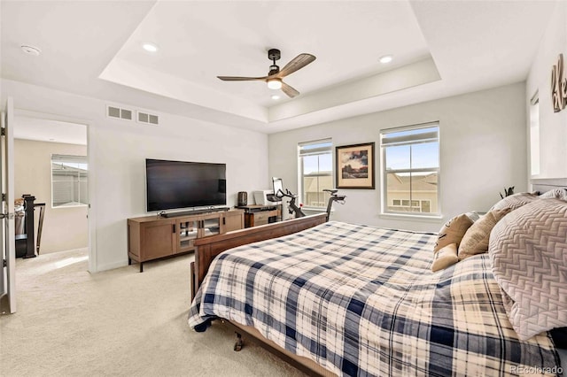 bedroom featuring a tray ceiling, light colored carpet, baseboards, and recessed lighting