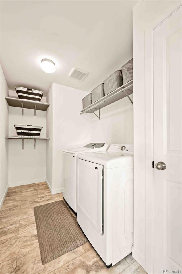 laundry room featuring laundry area, washing machine and dryer, visible vents, and baseboards