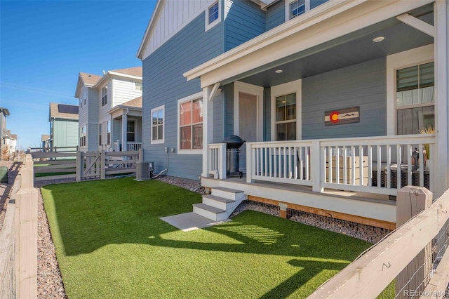 doorway to property featuring a lawn, central AC unit, a porch, and board and batten siding