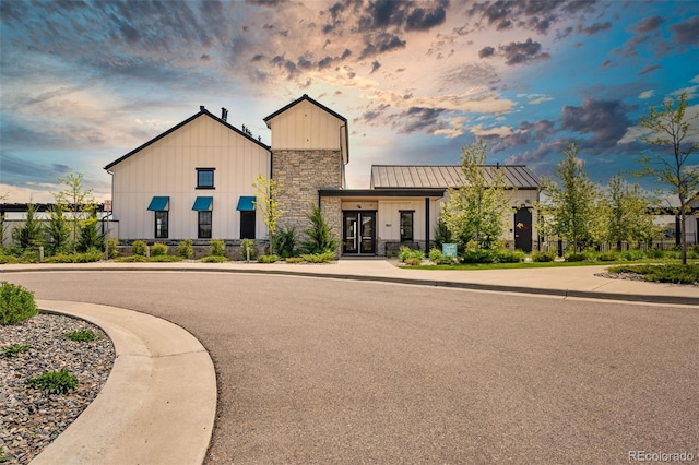 view of front of home featuring stone siding, metal roof, and a standing seam roof