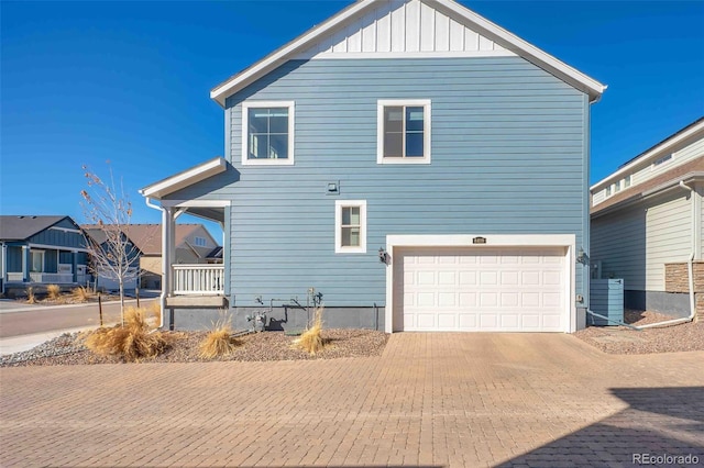 exterior space featuring a garage, decorative driveway, and board and batten siding