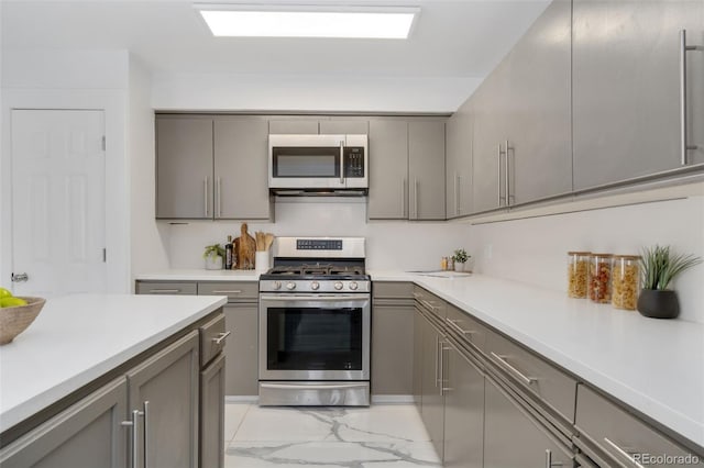 kitchen with stainless steel appliances and gray cabinetry