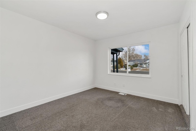 unfurnished room with dark carpet