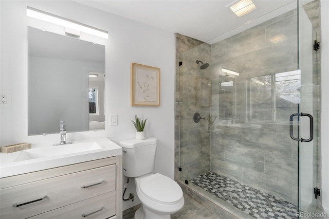 bathroom with vanity, a shower with shower door, and toilet