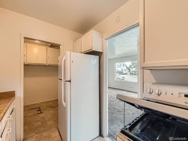 1850 W 50th Ave, Denver, CO 80221 - kitchen featuring freestanding refrigerator, stove, light countertops, and white cabinets