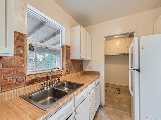 1850 W 50th Ave, Denver, CO 80221 - kitchen featuring freestanding refrigerator, white cabinets, light countertops, and light stone finish floors