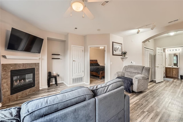 16320 E Fremont Ave Unit 1, Aurora, CO 80016 - living area with light wood-style flooring, ceiling fan, arched walkways, and a tiled fireplace