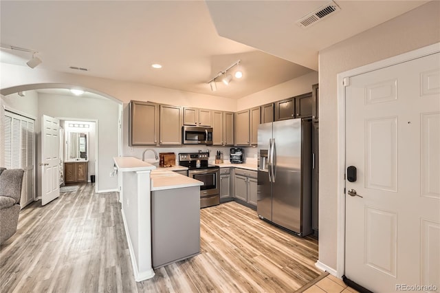 16320 E Fremont Ave Unit 1, Aurora, CO 80016 - kitchen with appliances with stainless steel finishes, arched walkways, track lighting, and light wood-type flooring