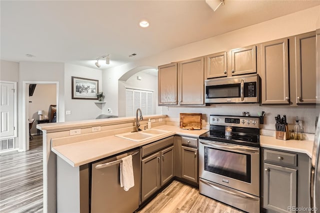 16320 E Fremont Ave Unit 1, Aurora, CO 80016 - kitchen featuring appliances with stainless steel finishes, a sink, gray cabinets, a peninsula, and light wood-style floors