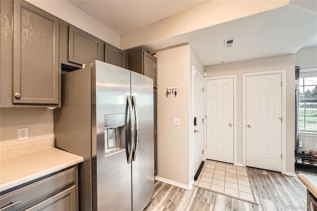 16320 E Fremont Ave Unit 1, Aurora, CO 80016 - kitchen featuring stainless steel fridge with ice dispenser, light wood finished floors, light countertops, gray cabinets, and baseboards