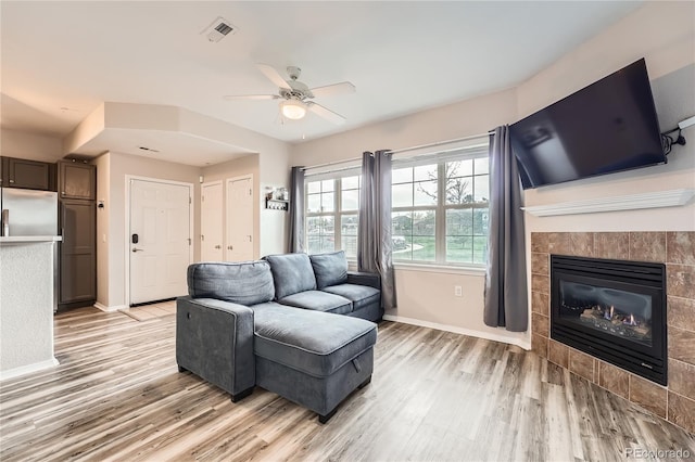 16320 E Fremont Ave Unit 1, Aurora, CO 80016 - living area with light wood-style flooring, baseboards, a ceiling fan, and a tile fireplace