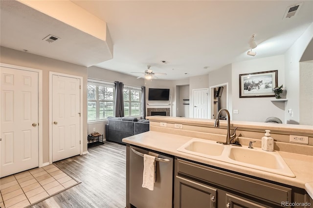 16320 E Fremont Ave Unit 1, Aurora, CO 80016 - kitchen featuring stainless steel dishwasher, a sink, a fireplace, light countertops, and ceiling fan