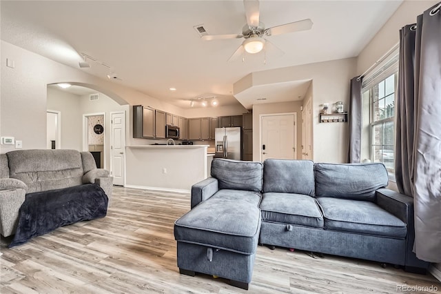 16320 E Fremont Ave Unit 1, Aurora, CO 80016 - living room with arched walkways, a ceiling fan, light wood finished floors, and track lighting