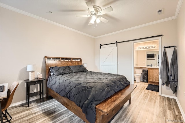 16320 E Fremont Ave Unit 1, Aurora, CO 80016 - bedroom featuring light wood-type flooring, a barn door, crown molding, baseboards, and connected bathroom