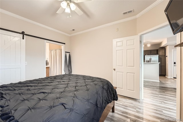 16320 E Fremont Ave Unit 1, Aurora, CO 80016 - bedroom with stainless steel refrigerator with ice dispenser, light wood-style floors, crown molding, a barn door, and ceiling fan