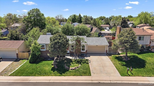 10832 W Powers Pl, Littleton, CO 80127 - view of front facade featuring a residential view, concrete driveway, an attached garage, a shingled roof, and brick siding