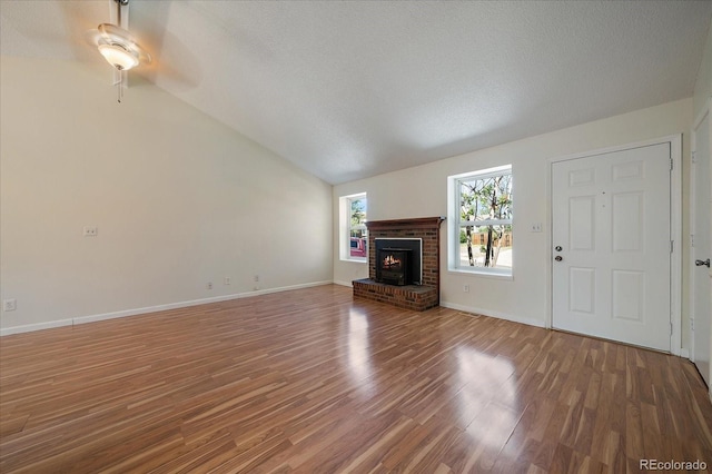10832 W Powers Pl, Littleton, CO 80127 - unfurnished living room with wood finished floors, a fireplace, a ceiling fan, a textured ceiling, and lofted ceiling