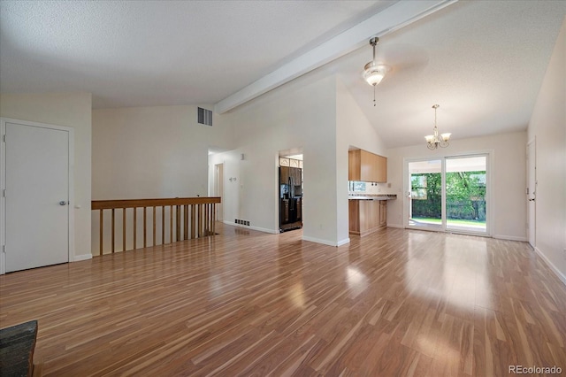10832 W Powers Pl, Littleton, CO 80127 - unfurnished living room with a chandelier, light wood finished floors, and baseboards