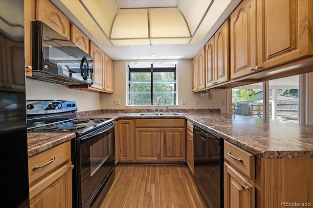 10832 W Powers Pl, Littleton, CO 80127 - kitchen featuring black appliances, a sink, light wood-style floors, and dark countertops
