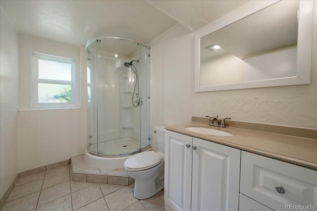 10832 W Powers Pl, Littleton, CO 80127 - bathroom featuring toilet, a stall shower, vanity, tile patterned flooring, and baseboards