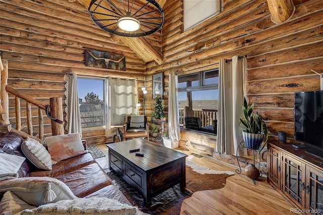 14475 N Yoder Rd, Calhan, CO 80808 - living room featuring rustic walls, wood finished floors, stairs, high vaulted ceiling, and beamed ceiling