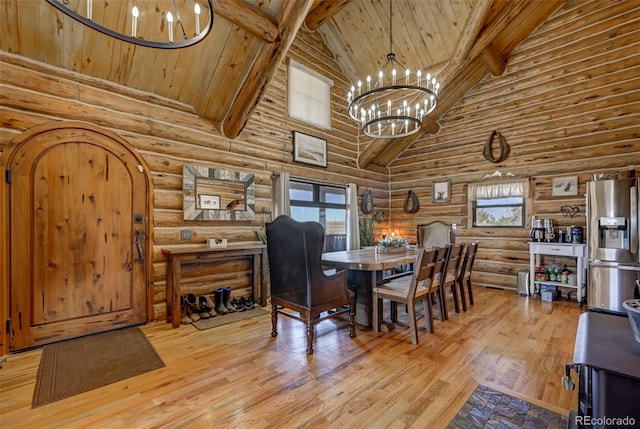 14475 N Yoder Rd, Calhan, CO 80808 - dining space with high vaulted ceiling, rustic walls, a chandelier, beam ceiling, and light wood-style flooring