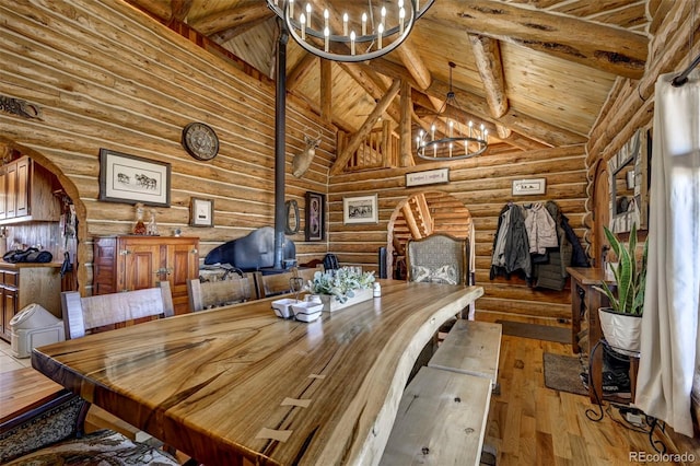 14475 N Yoder Rd, Calhan, CO 80808 - dining area featuring a chandelier, log walls, hardwood / wood-style floors, wooden ceiling, and beamed ceiling