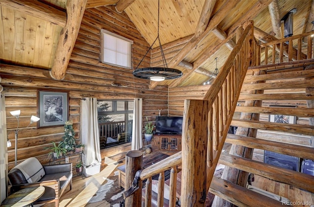 14475 N Yoder Rd, Calhan, CO 80808 - stairway featuring high vaulted ceiling, wood ceiling, log walls, beamed ceiling, and wood finished floors