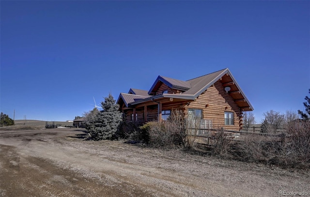 14475 N Yoder Rd, Calhan, CO 80808 - view of property exterior featuring metal roof and log exterior