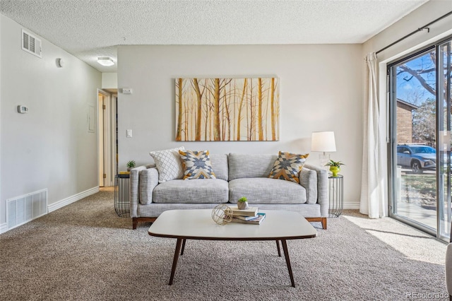 carpeted living area featuring visible vents, a textured ceiling, and baseboards