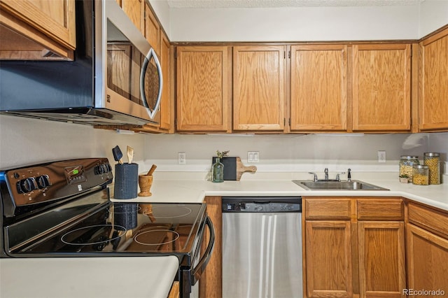 kitchen featuring a sink, brown cabinets, appliances with stainless steel finishes, and light countertops