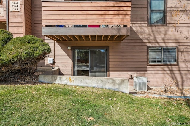 property entrance with central air condition unit and a yard