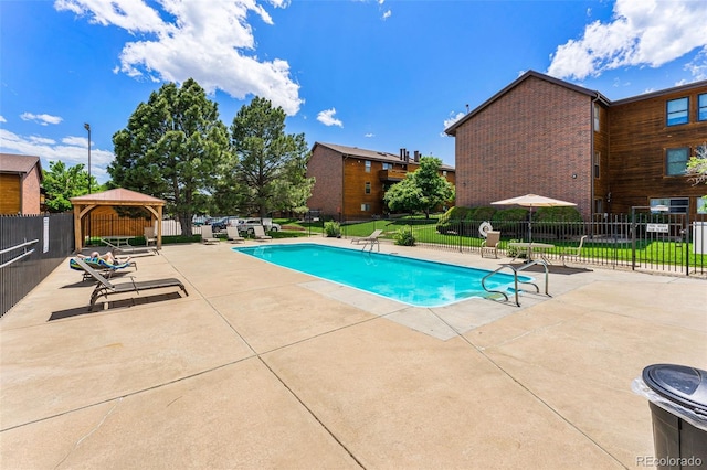 pool featuring a gazebo, fence, and a patio area
