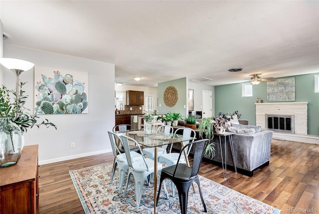 dining space with dark wood-type flooring, ceiling fan, and sink