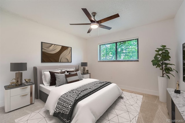 bedroom featuring light carpet, ceiling fan, and baseboards