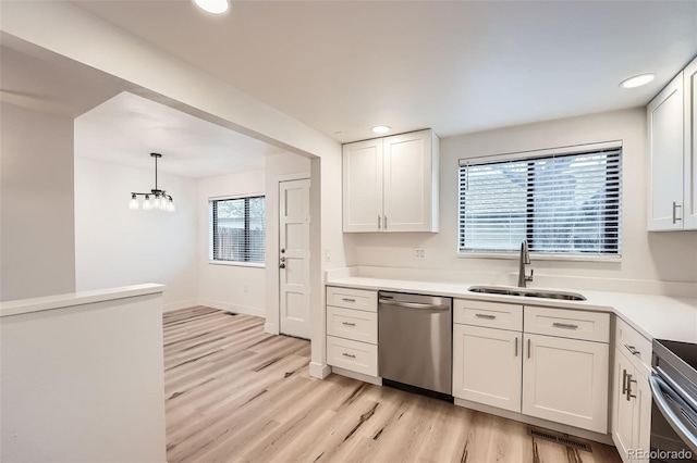 kitchen with dishwasher, a sink, light wood-type flooring, white cabinets, and recessed lighting