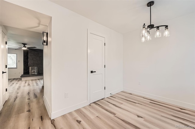 unfurnished dining area featuring light wood-style floors, ceiling fan, and baseboards