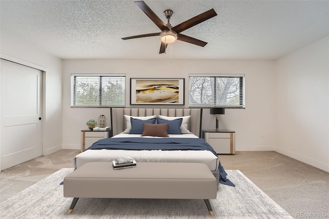 bedroom featuring carpet flooring, a textured ceiling, a ceiling fan, and baseboards