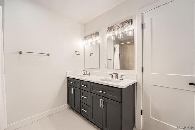bathroom with baseboards, double vanity, and tile patterned floors
