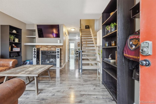 interior space with built in shelves, a textured ceiling, and hardwood / wood-style floors