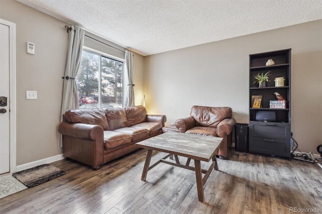 living room featuring dark wood-type flooring and a textured ceiling