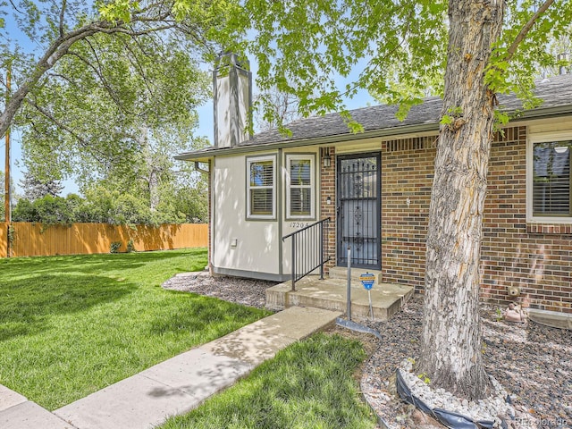 doorway to property featuring brick siding and a chimney
