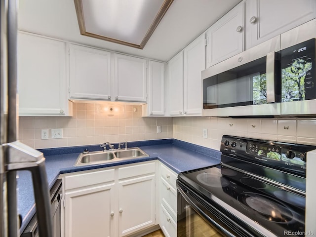 kitchen with electric range, stainless steel microwave, a sink, and dark countertops