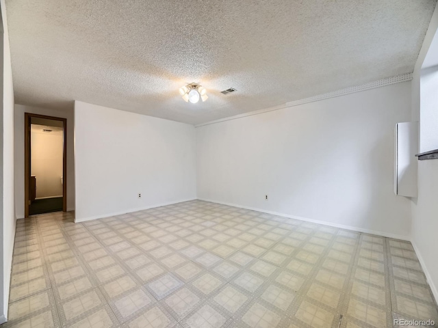 unfurnished room featuring a textured ceiling, baseboards, and light floors