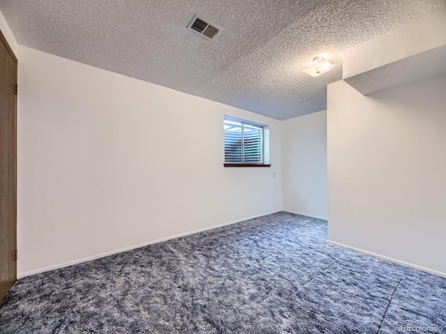 unfurnished room featuring carpet, a textured ceiling, and baseboards